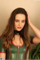 A woman in a green and red latex outfit posing for a picture.